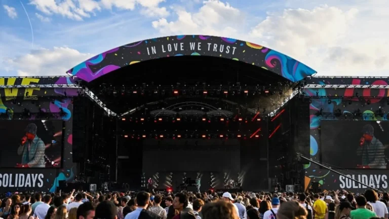 Grande scène Solidays 2026 sous le slogan "In Love We Trust" à l'Hippodrome de Longchamp, foule dense au coucher du soleil