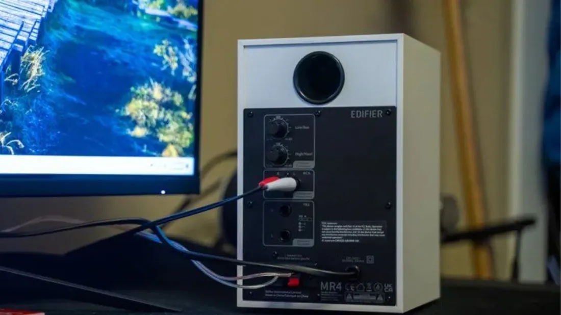 Panneau arrière de l'Edifier MR4 blanche branchée : câble RCA rouge et blanc dans les entrées, câble haut-parleur vers l'enceinte passive, évent bass-reflex
