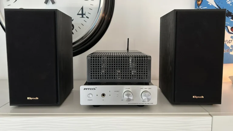 Paire de Klipsch R-41M noires encadrant un ampli à tubes RFTLYS eA1A sur un meuble blanc, le setup testé à la maison