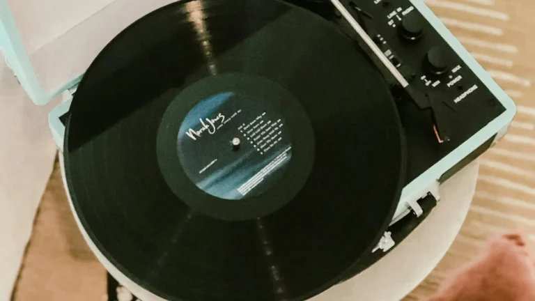 Platine vinyle avec enceinte intégrée : valise Victrola turquoise lisant un disque dans un salon